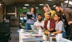 Agency coworkers discussing new project on laptop