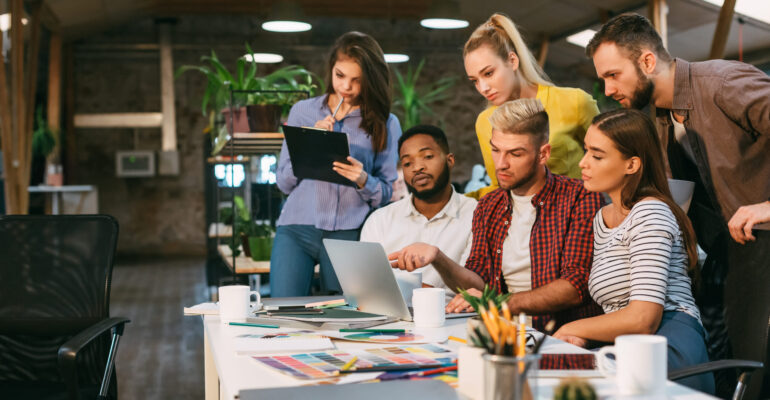 Agency coworkers discussing new project on laptop